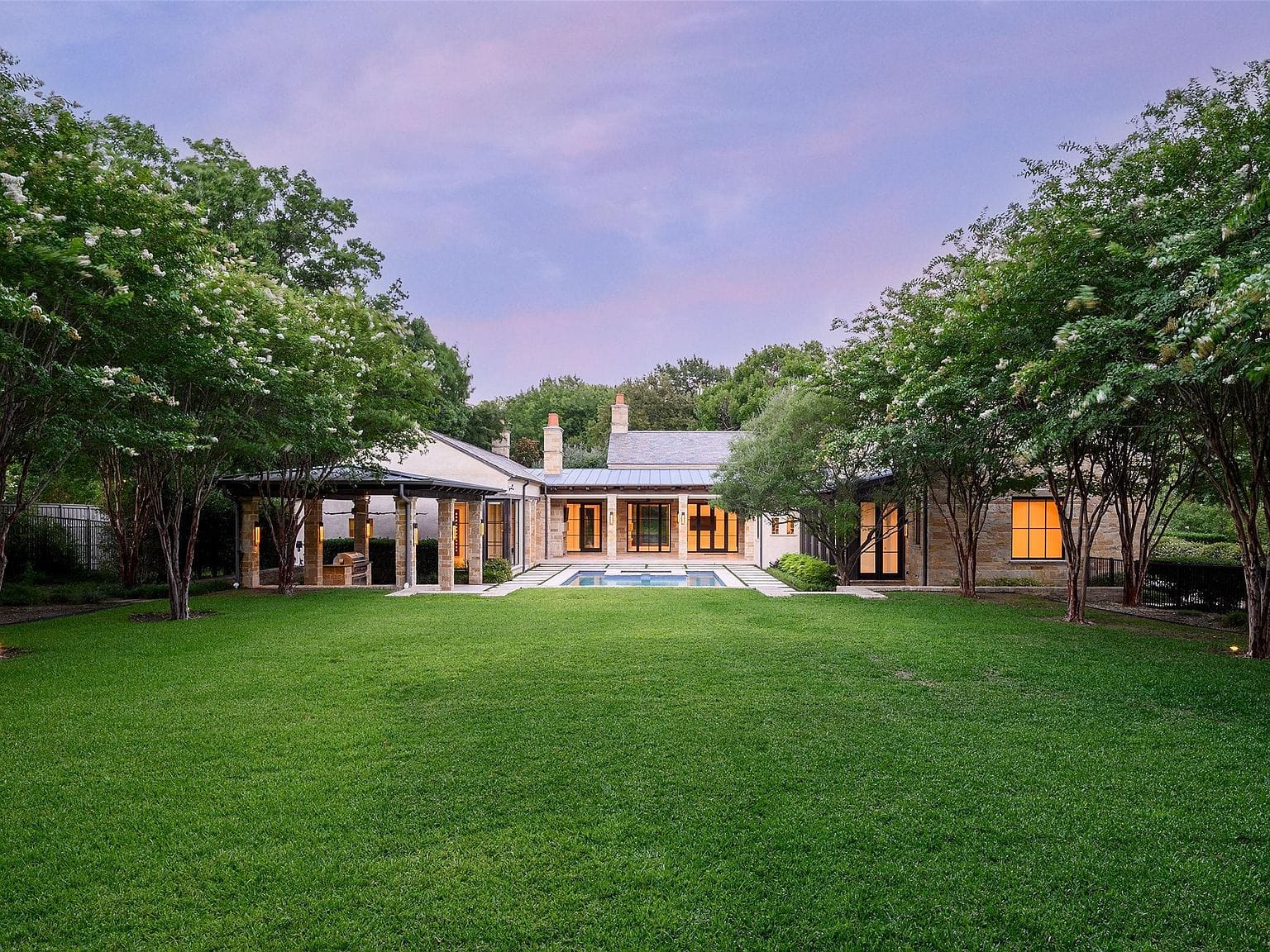 secluded estate framed by expansive lawn and mature trees
