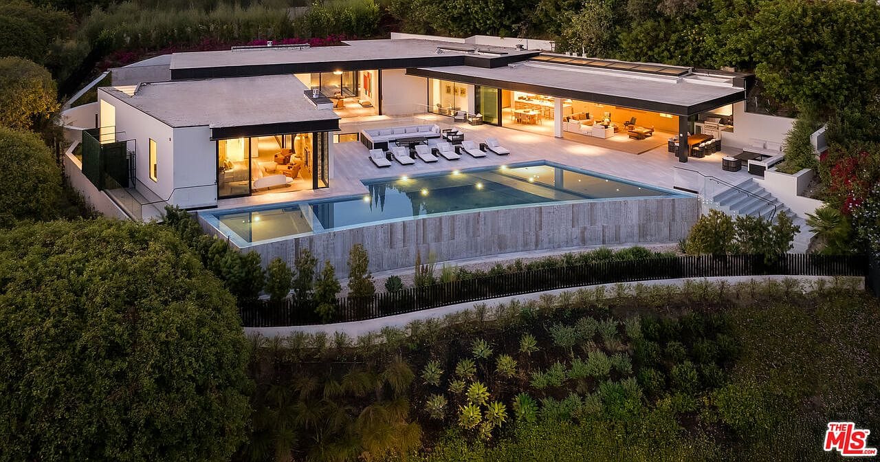twilight aerial of the compound with infinity pool and city lights