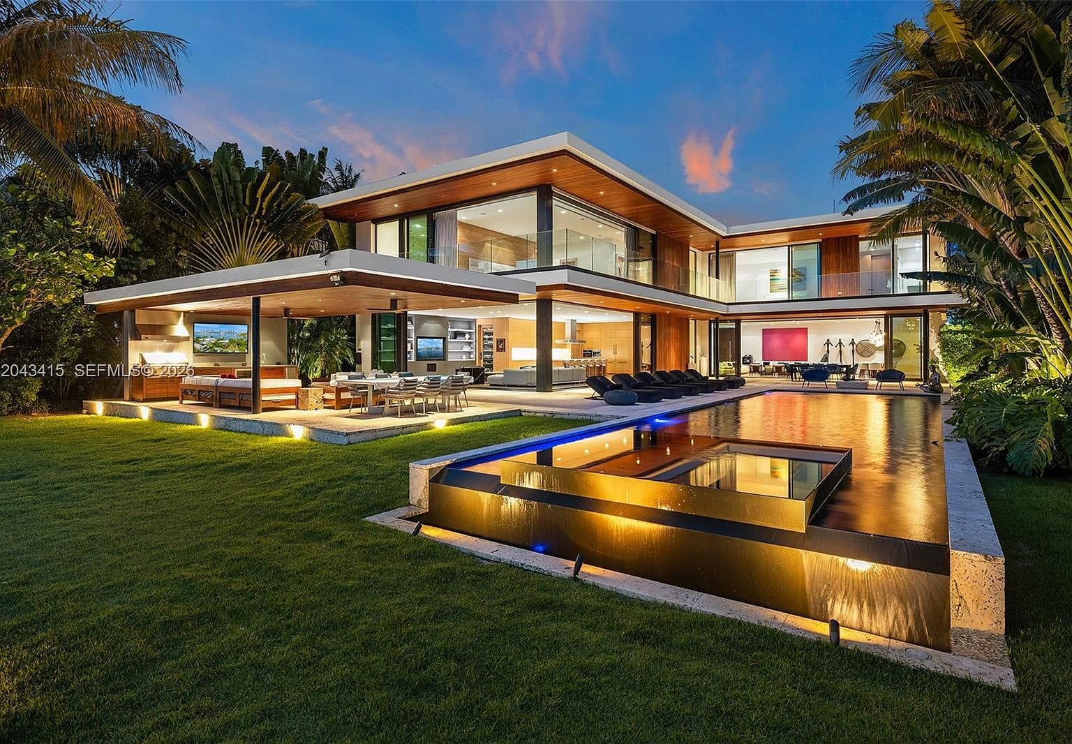 twilight waterfront estate with negative-edge pool and warm wood soffits