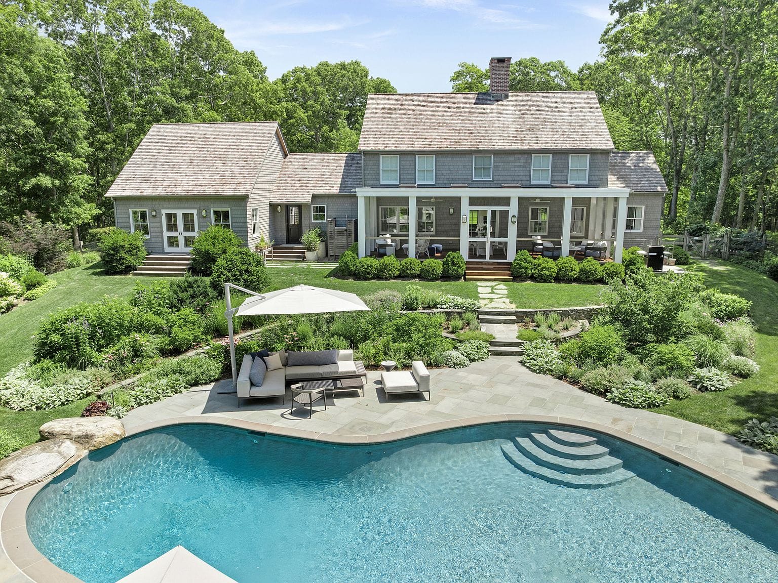 pool and residence framed by manicured grounds