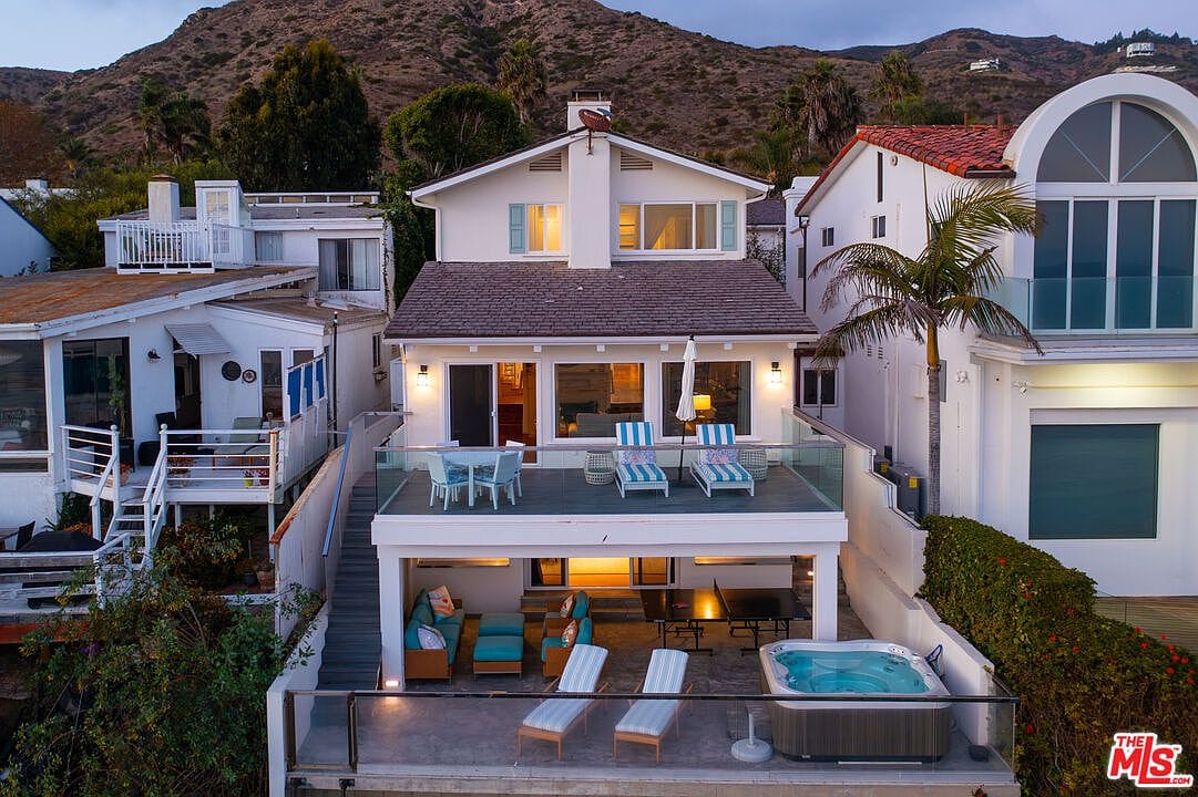 twilight rear elevation, three deck levels lit, hot tub, ocean beyond