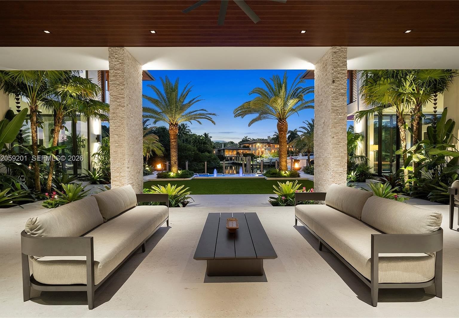 twilight courtyard with the oversized pool and glowing pavilions