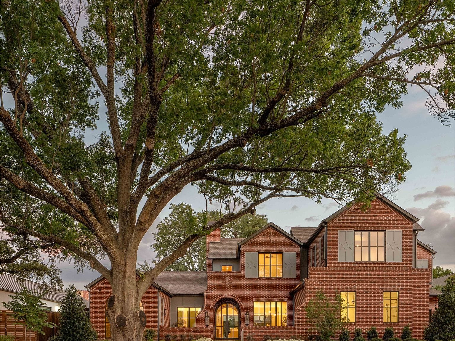 brick residence framed by mature trees