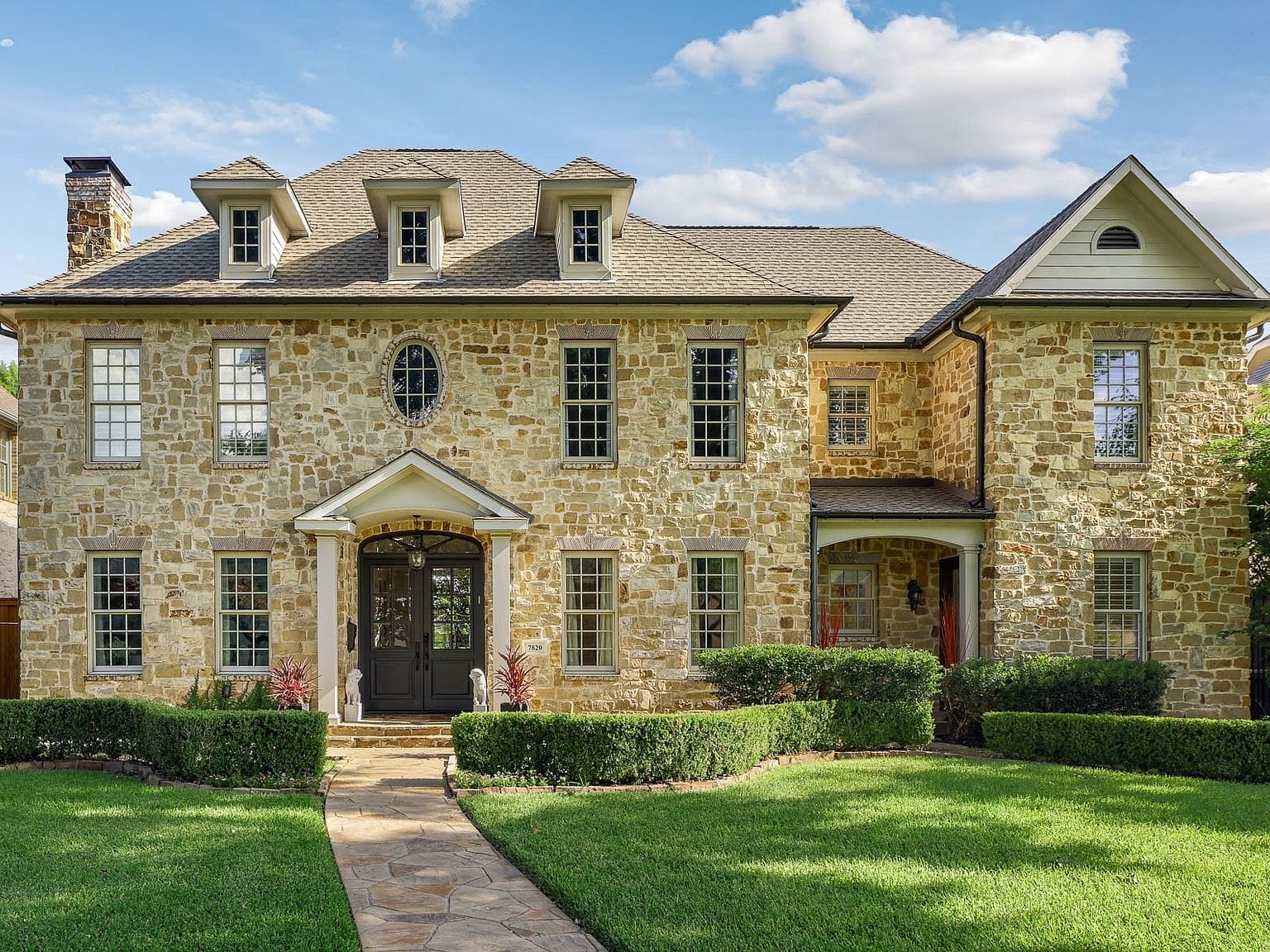 timeless stone facade and manicured front lawn